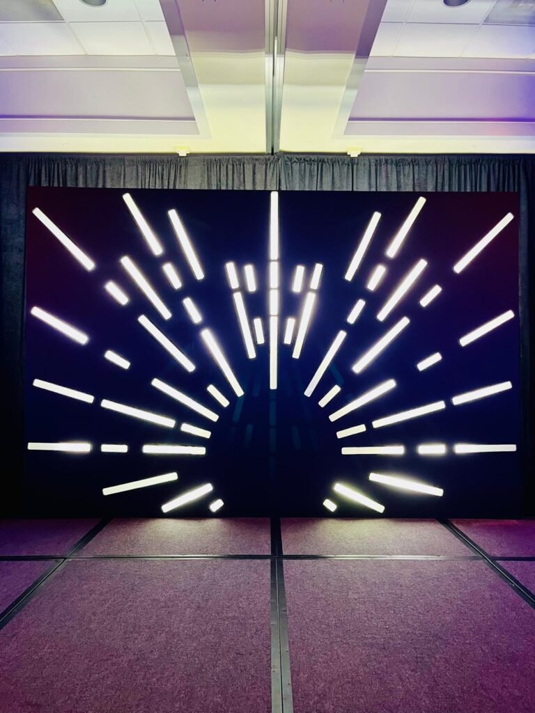 LED sunburst stage set glowing behind a conference stage