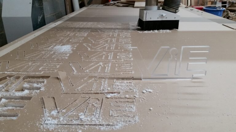 Acrylic logo pieces on the CNC bed